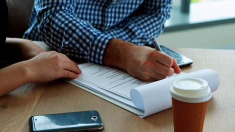 executive signing contract at desk