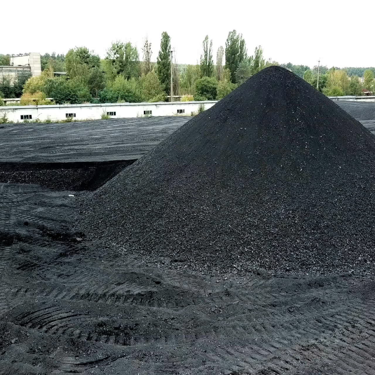 Bulldozer sorts coal. Extractive industry, anthracite. Coal industry. Aerial view.