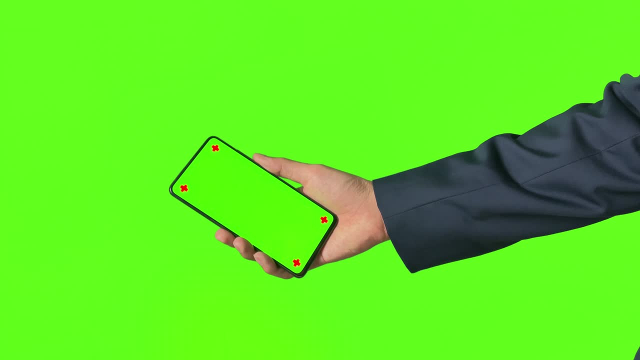 사업가 손은 녹색 배경에 녹색 화면을 가진 모바일 스마트폰을 보여줍니다.