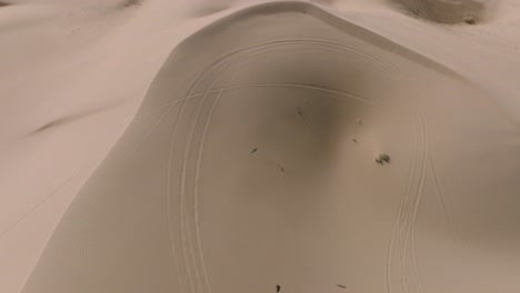 부드러운 모래 지형 위를 날아다니는 새들, 캘리포니아 남부 글라미스에 있는 모래 언덕 위치의 공중 드론 샷