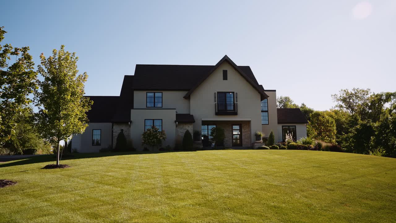 the exterior of a large luxury home with a large front yard