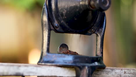 Roasted-coffee-being-ground-manually