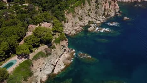 flying next to a house on the coast of the mediterranean sea