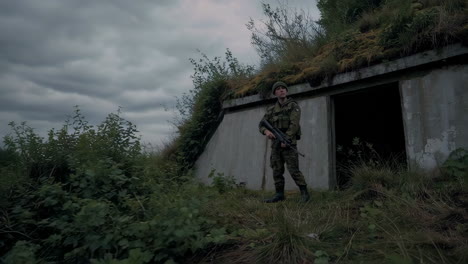 soldier on watch at a bunker in the woods
