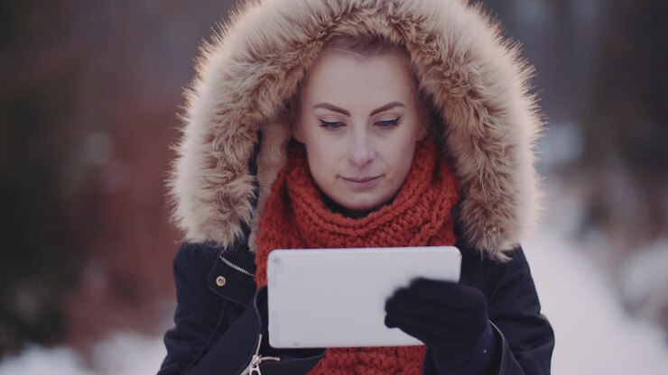 Turista che usa un tablet digitale nel bosco in inverno 1