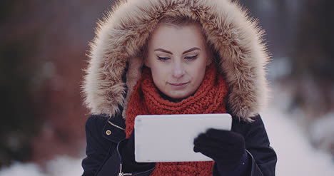 female tourist using digital tablet in forest in winter 1