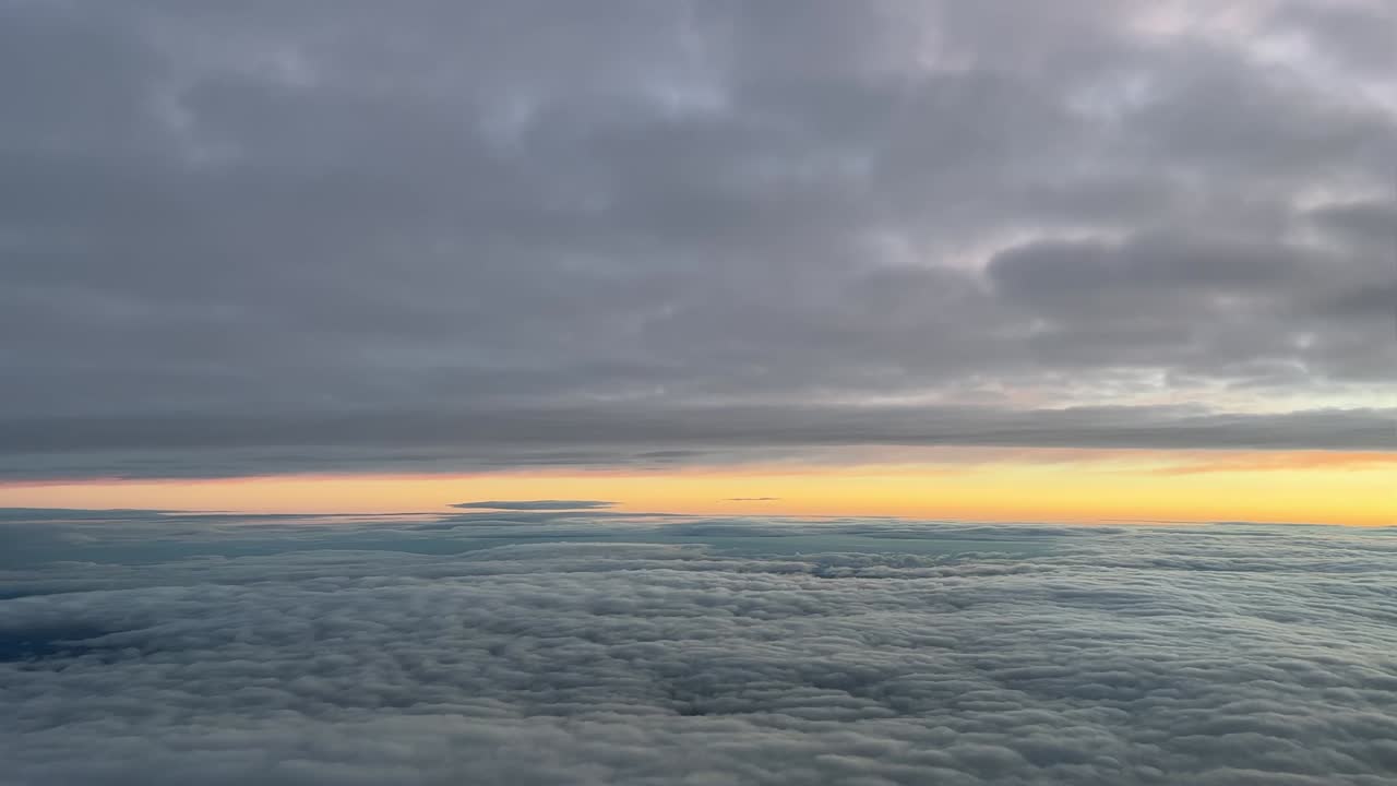 vista piloto desde una cabina de jet mientras volaba entre capas de nubes al amanecer con un cielo naranja, a 10000m de altura en una fría mañana de invierno