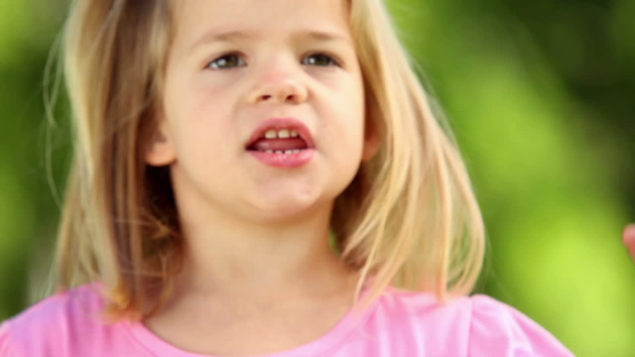 Bambina che gioca con una girandola al parco