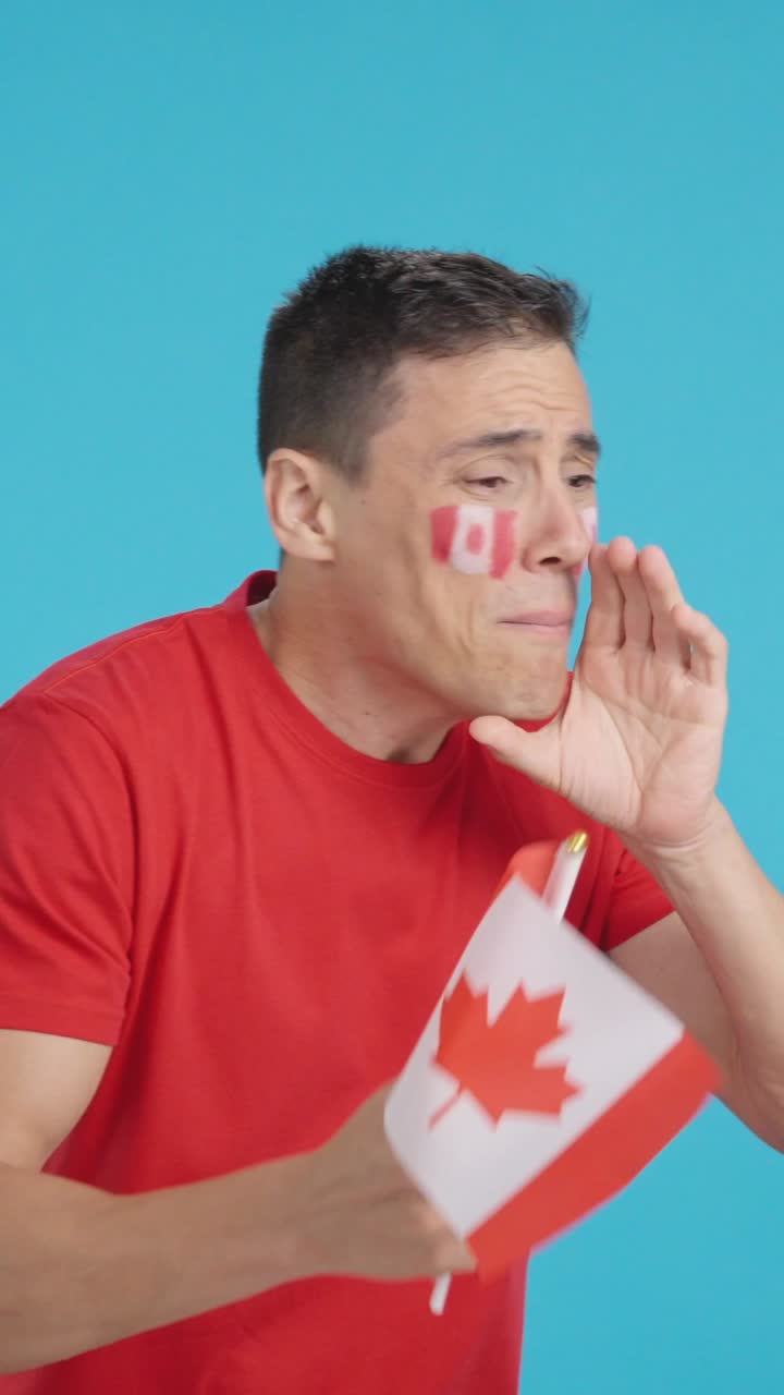 Nervous man cheering for Canada during a match looking away