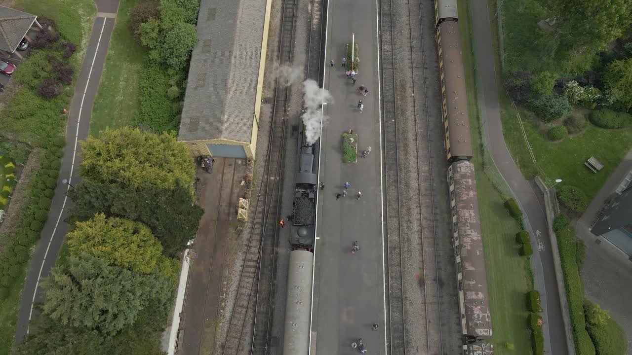 Aerial view of the Minehead steam railway station England's longest heritage line, running 20 miles between Minehead and Bishops Lydeard. Drone moving backwards and camera tilting up over station