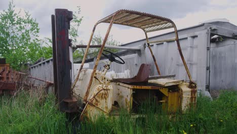 A-pallet-stacker-left-in-the-grass-rotting-and-rusting-away-in-slow-motion