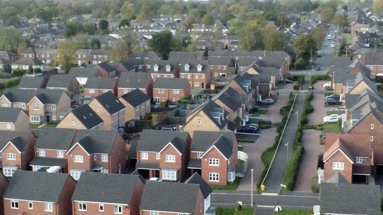 Property ladder new British housing estate aerial view overlooking rooftops dolly left