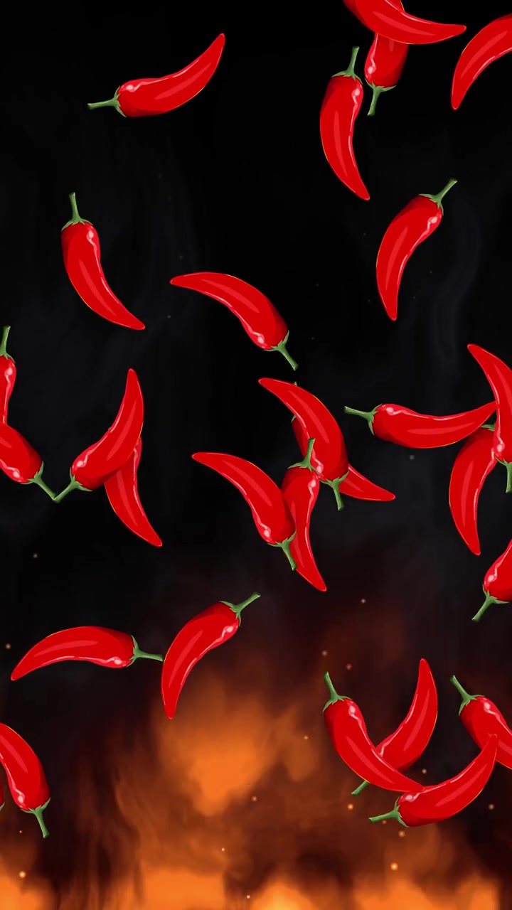 Peperoncini rossi che cadono attraverso il fumo sopra fiamme ardenti su uno sfondo verticale nero
