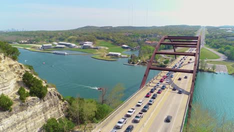 Verkehr-Von-Stoßstange-Zu-Stoßstange-Auf-Der-Pennybacker-Bridge-Mit-Blick-Auf-Austin,-Texas-In-Der-Oberen-Linken-Ecke