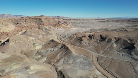 Vista-Aérea-De-Caminos-Desérticos-Bajo-Colinas-De-Arenisca,-Moab,-Idaho-Usa,-Disparo-De-Drone