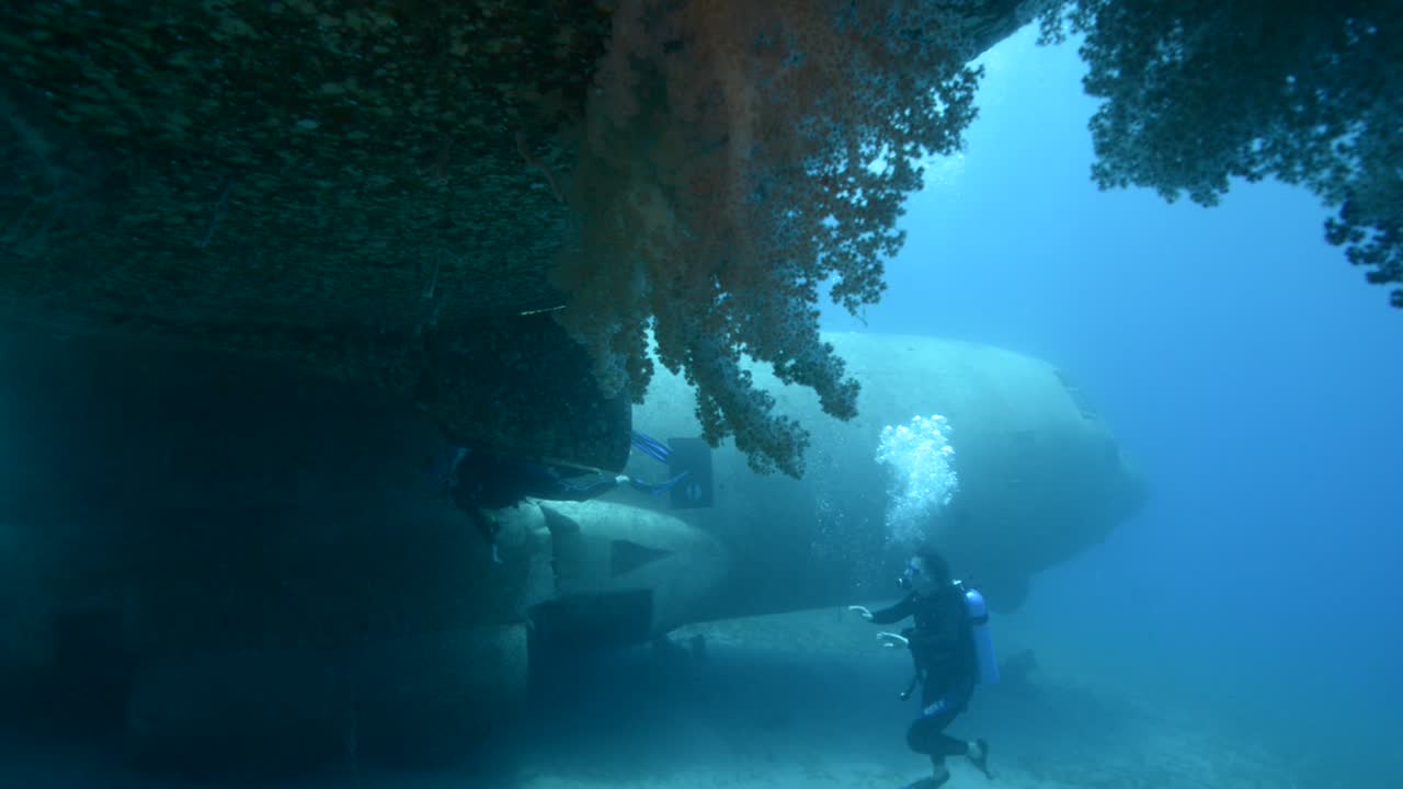 아카바 요르단 2 근처의 홍해에서 침몰한 비행기를 탐험하는 스쿠버 다이버들의 수중 영상