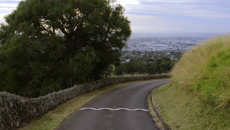 Walking-alone-on-curvy-alley,-gloomy-midday-in-Auckland,-New-Zealand---handheld-shot