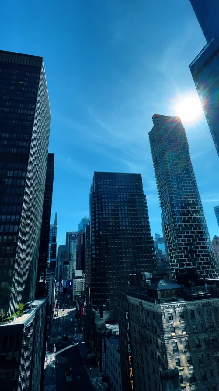 Arranha-céus de vidro refletindo edifícios da cidade sob sol forte e céu azul. Torres de escritórios modernas de vidro com reflexos de luz solar e da arquitetura circundante em Manhattan, Nova York.