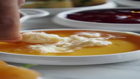 close up of honey and butter with a small bite of bread