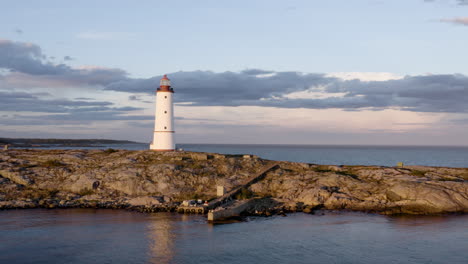 lille torungen lighthouse by sea against cloudy sky during sunset in arendal, norway - aerial drone shot