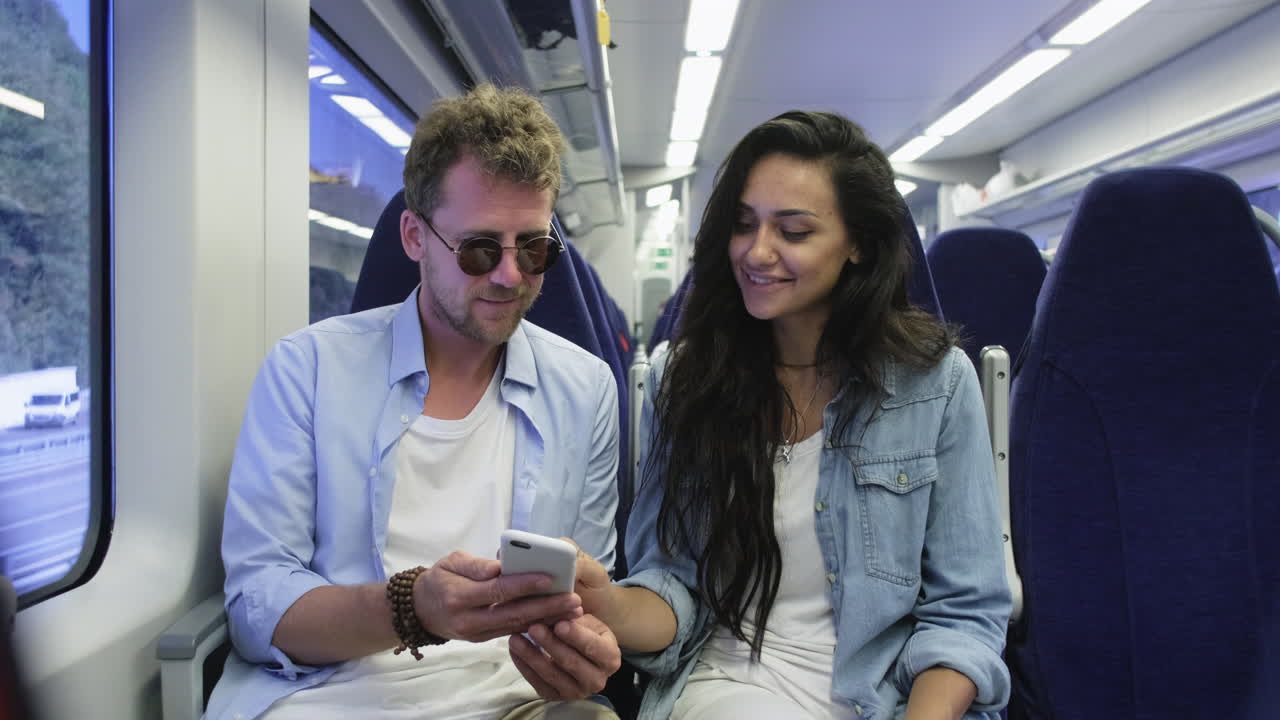 una pareja usando un teléfono inteligente en un tren