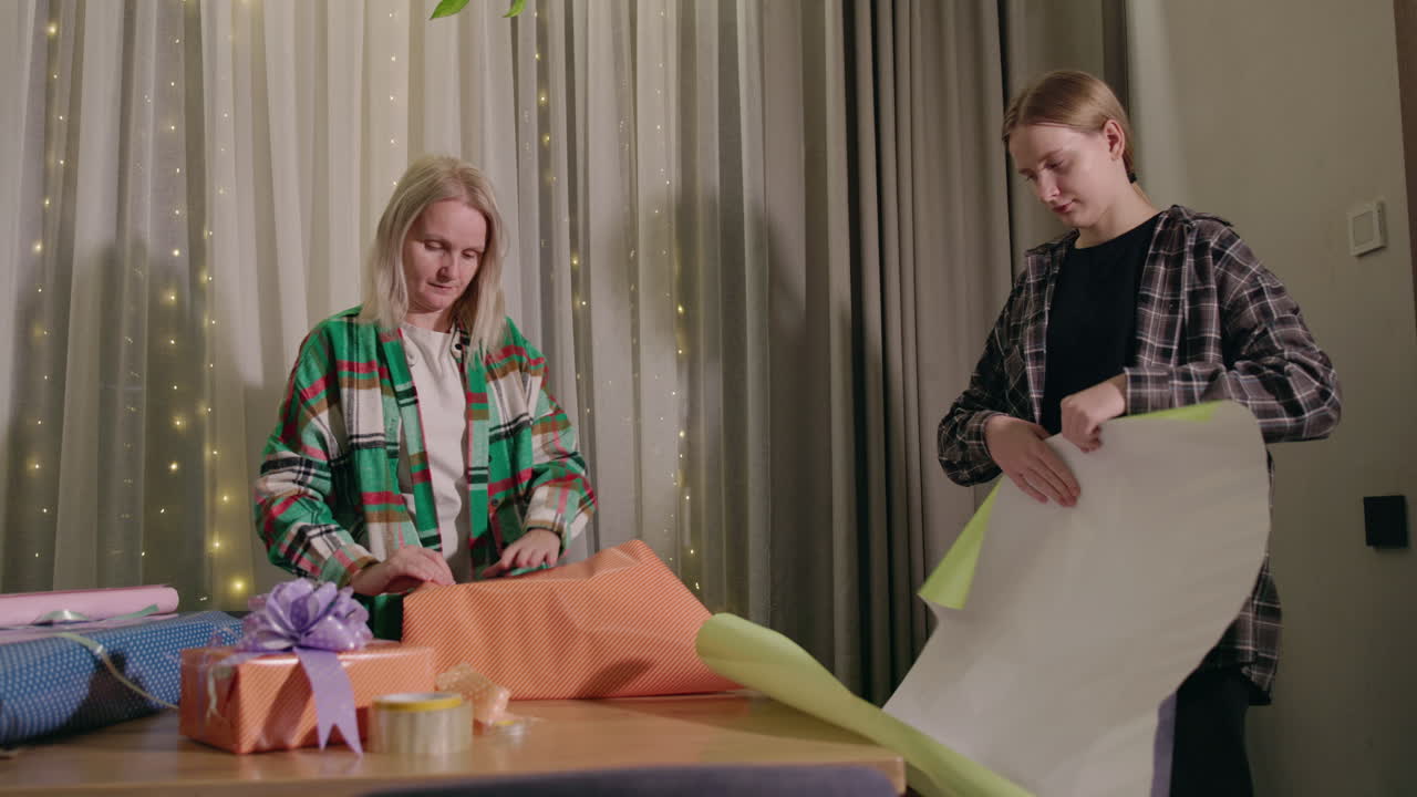 мать и дочь упаковывают подарки вместе