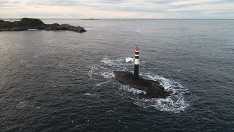 vista aérea del faro con olas rompiendo en el mar noruego en noruega
