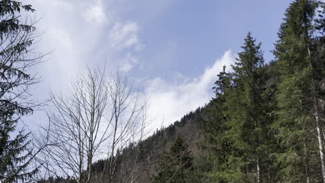 Helicopter-flying-over-mountains-at-low-altitude-with-a-cargo