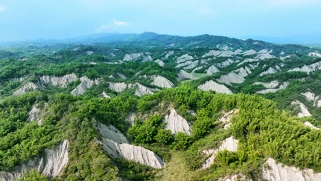 Luftpanorama-Der-Wunderschönen,-Mit-Grünen-Bäumen-Bedeckten-Mondweltlandschaft-In-Asien---Tairyo-Moon-World-Badland