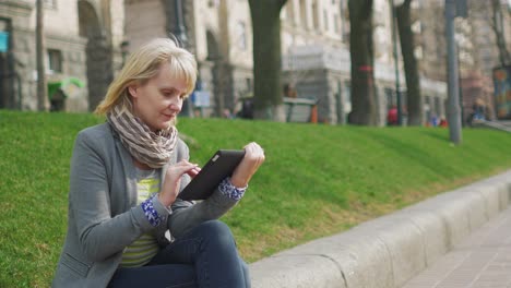 mujer joven descansando en el parque disfruta de un video de tableta digital 4k