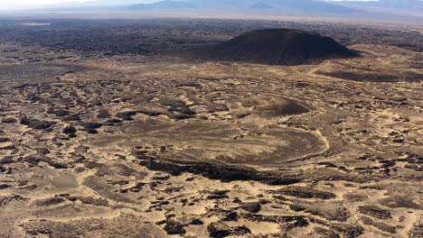 Aerial-cinematic-panoramic-view-of-Amboy-Crater-lava-field-Mojave-Desert-of-southern-California,-drone-reveal-scenic-natural-unpolluted-landscape-on-the-famous-Route-66-USA