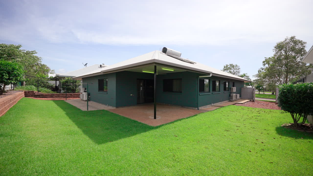 colorido gris moderno construido área de patio trasero pequeño con bloque de hormigón y césped en forma de l