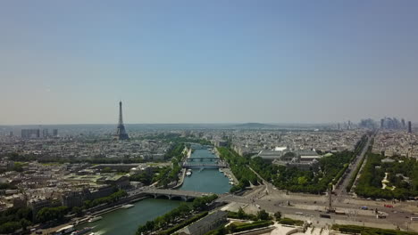 Luftaufnahmen-Des-Flusses,-Der-An-Einem-Sonnigen-Tag-Durch-Die-Stadt-Fließt.-Eiffelturm,-Der-über-Die-Umliegenden-Gebäude-Hinausragt.-Landungsaufnahmen-Im-Tuileriengarten.-Paris,-Frankreich