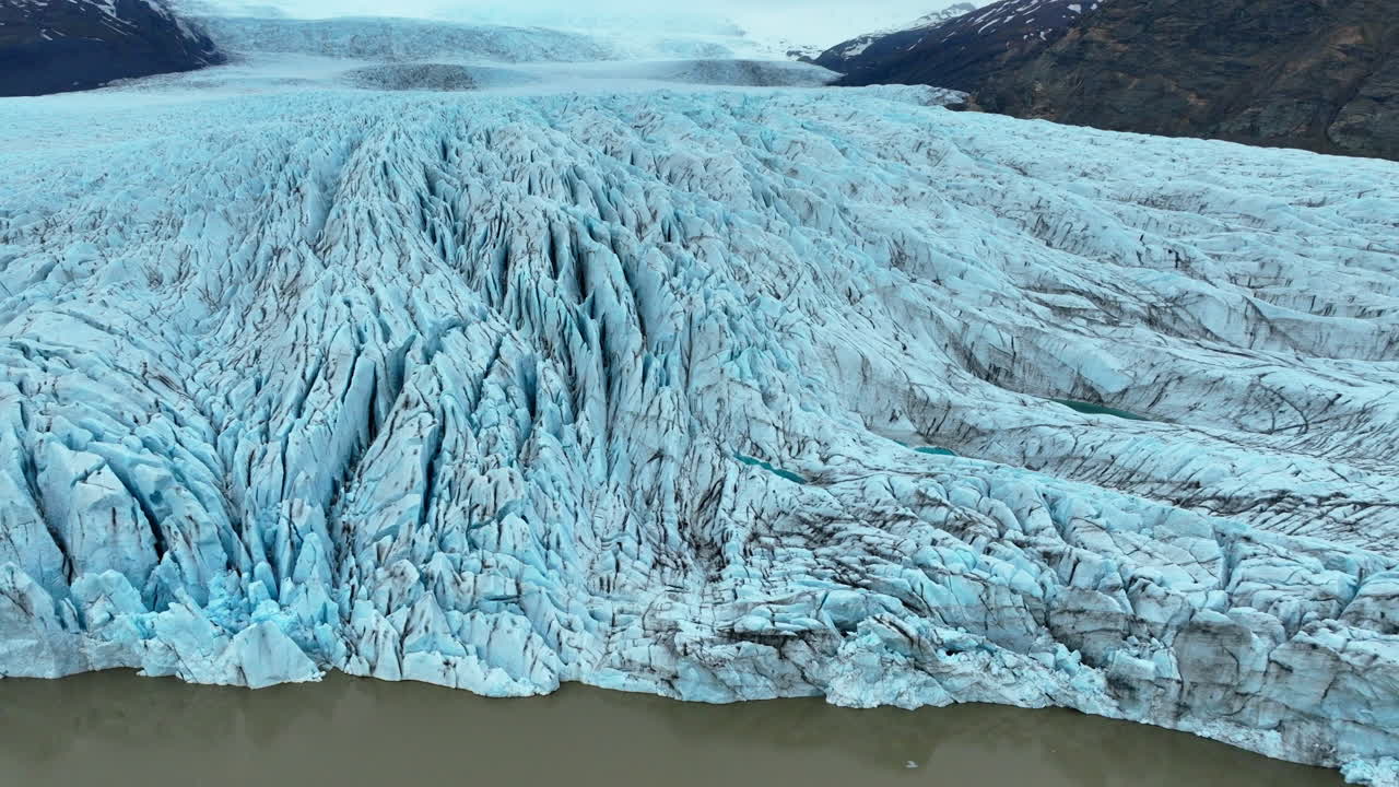 Drone footage capturing the massive ice formations and crevasses of a retreating glacier in Iceland