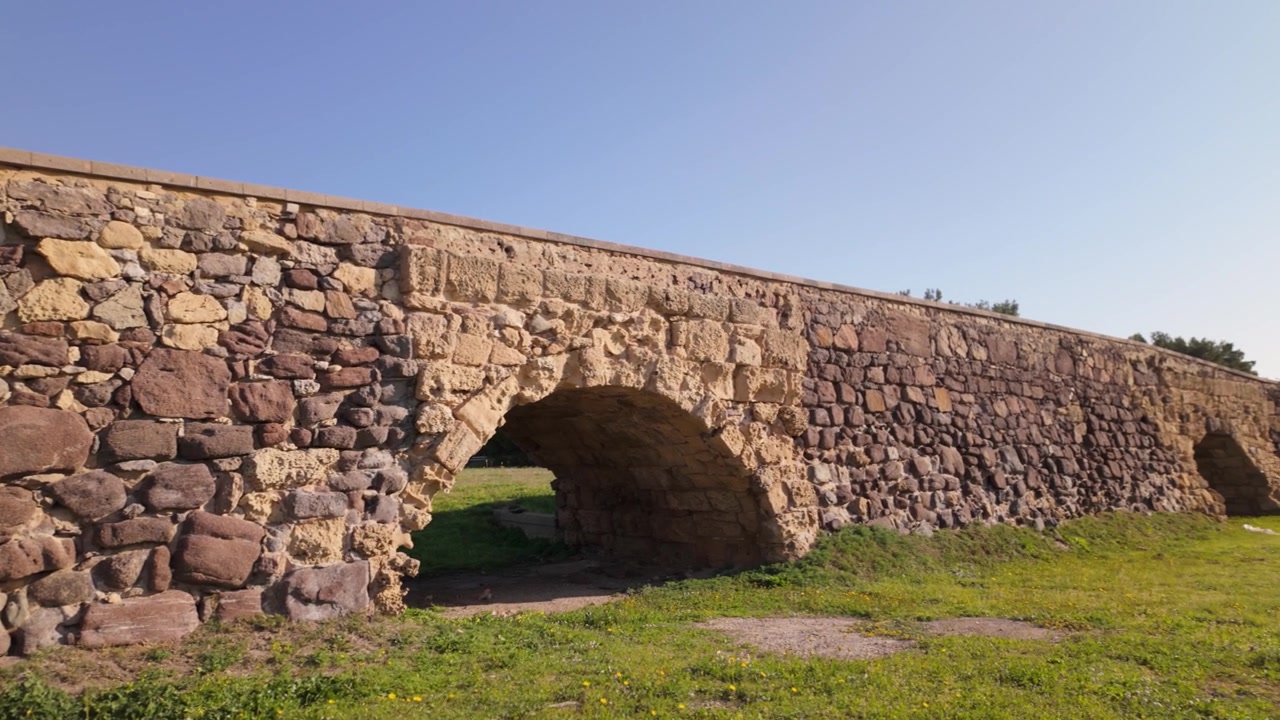 Roomalainen silta Sant'Antiocossa, Sardiniassa, Italiassa, näyttää historiallisen kivisillan ja ympäröivän maiseman.