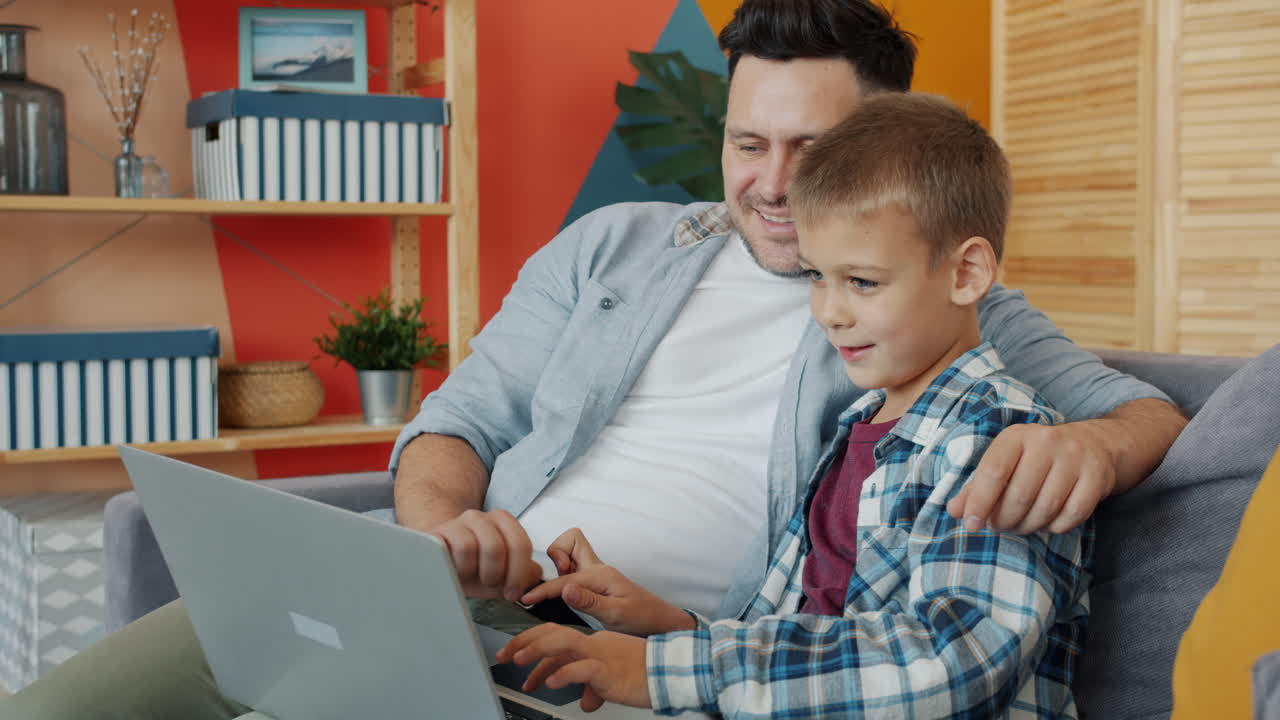 Father and Son using Laptop Together at Home