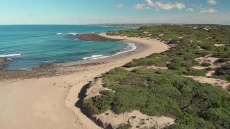 Playa-De-Surf-Aéreo-En-Un-Día-Cálido-Y-Soleado-Con-Puntos-Rocosos