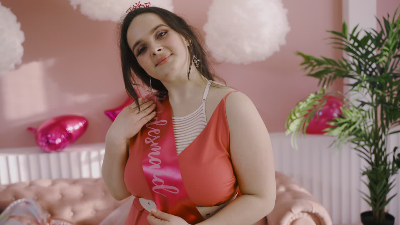 vista frontal de una mujer morena con novia para ser guillotina y tocado en despedida de soltera posando en cámara