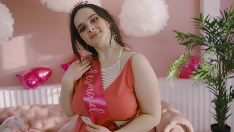 front view of a brunette woman with bride to be sash and headdress in bachelorette party posing at camera