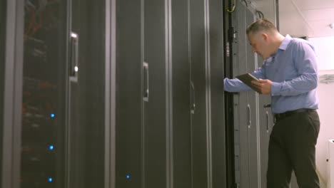 technician using tablet pc while analysing server