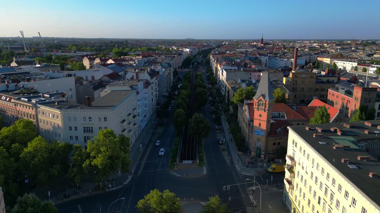 Žlutý nadzemní vlak projíždějící obytnou čtvrtí Berlína v létě. Nejlepší letecký pohled z dronu.