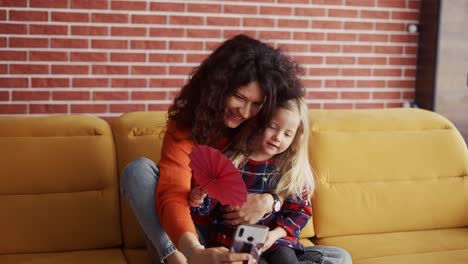 Mother-and-her-little-daughter-taking-selfie-at-home