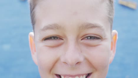 retrato de un escolar caucásico feliz con una pared de escalada en el fondo