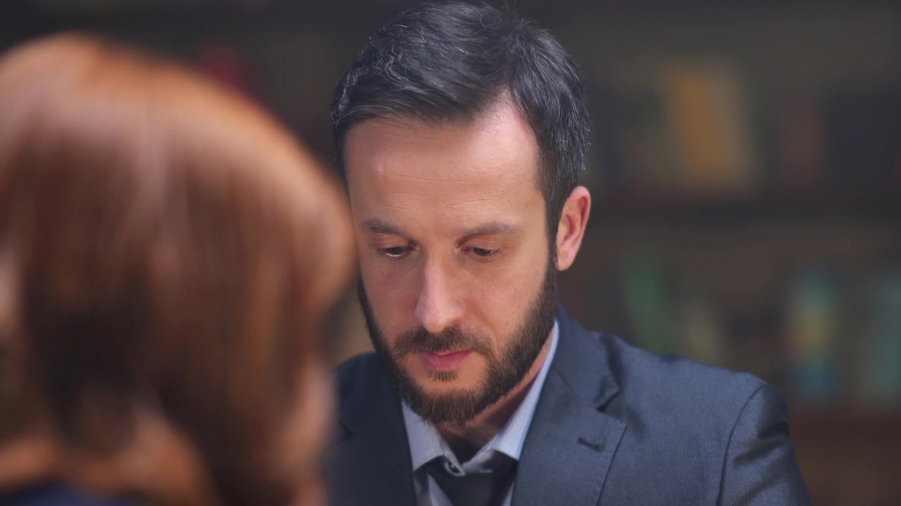Toplantı Sırasında Aşağı Bakan Takım Elbiseli Odaklanmış İş Adamı