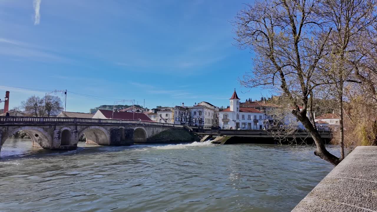 Veduta panoramica del lungofiume di Tomar con ponte storico ed edifici