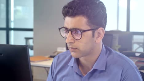 un joven empleado de oficina dedicado trabajando en un proyecto.