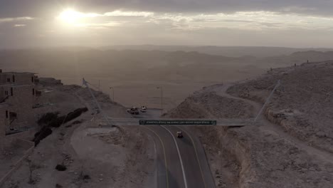 desert mountain road at sunset with bridge and cars