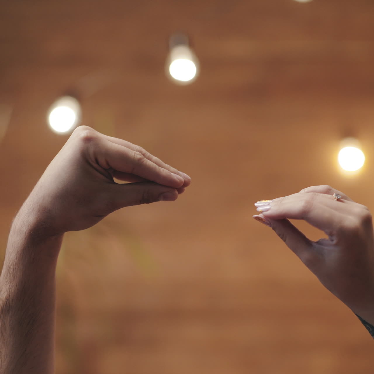 Romantic view of two hands playing with love together. Male and female hands isolated on blurred background. Love relationship concept.