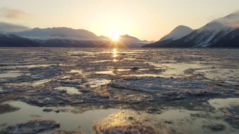 antena cinematográfica perfecta volando sobre capas de hielo cámara inclinada hacia arriba que revela el amanecer