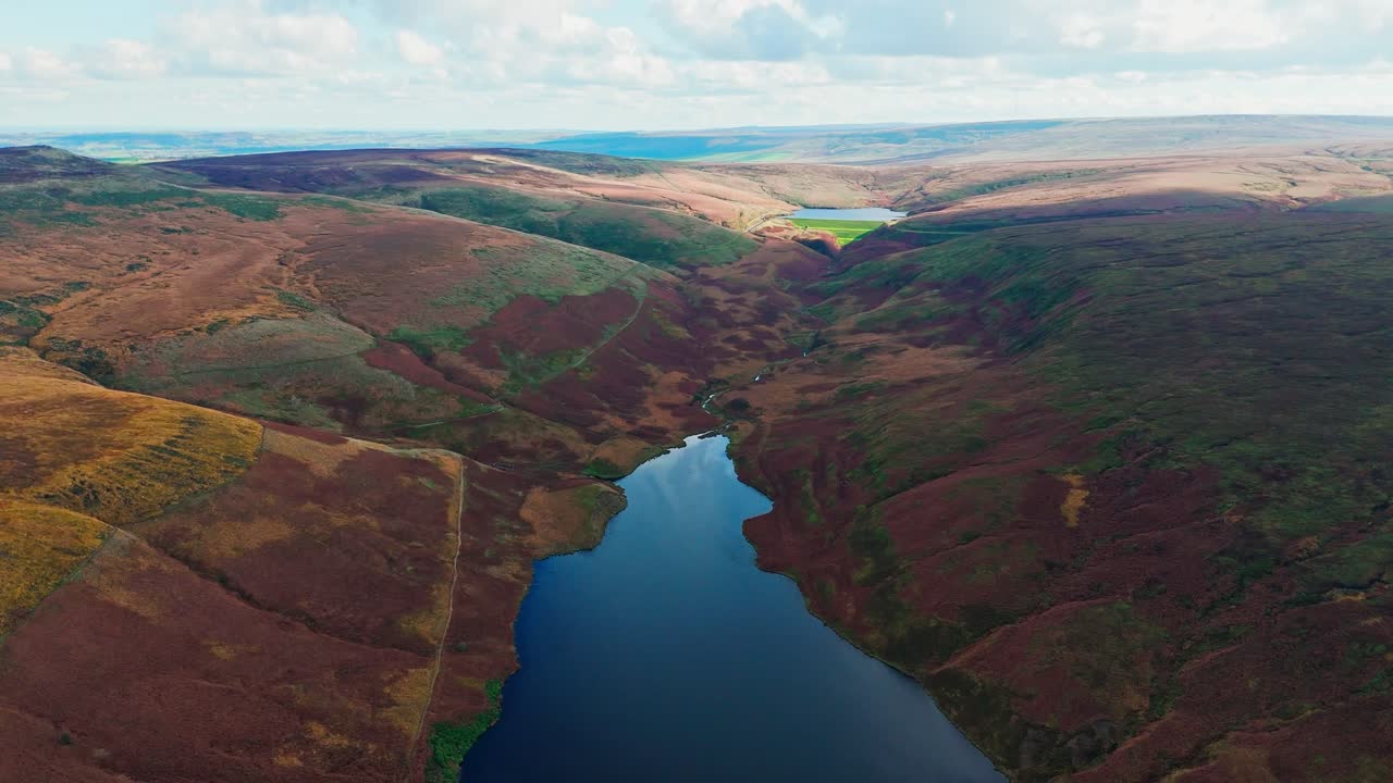 아름다운 영국 시골의 드론 영상, 야생 풍경, 헤더로 인 습지, 큰 호수 및 파란 물을 보여줍니다.